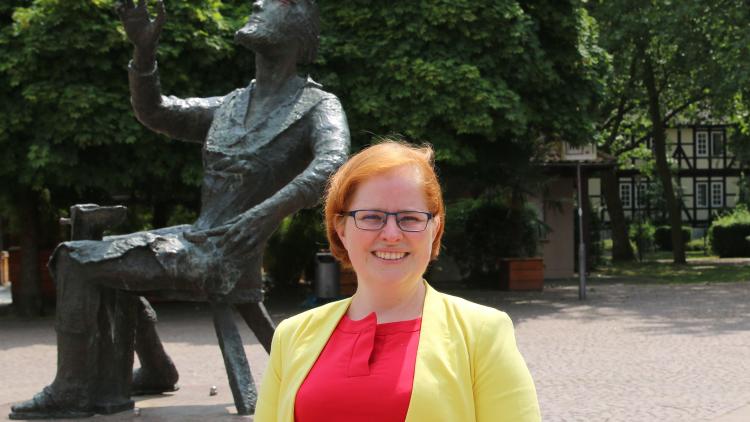 Ratsfrau Anika Lilienthal vor dem Wicken-Thies Brunnen auf dem Spittaplatz